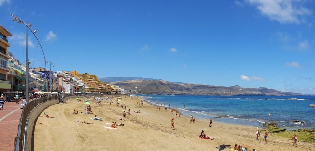 Vista Panorámica de Playa de las Canteras en Las Palmas de Gran Canaria: Una vista impresionante de la extensa Playa de las Canteras, donde la arena dorada se encuentra con las aguas cristalinas del Atlántico.